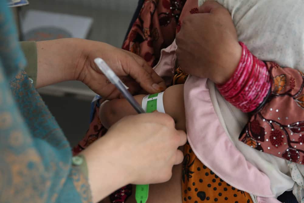 MSF nurse Aziza Khushal measures Gull Sima’s arm with a mid-upper arm circumference (MUAC) tape in a consultation room on the women's side of the Médecins Sans Frontières (MSF) drug-resistant tuberculosis (DR-TB) hospital in Kandahar city, Kandahar Province, Afghanistan. MUAC tapes are used to help identify malnutrition. MSF performs contact tracing with all family members of TB and DRT patients in order to check if they have symptoms of TB.