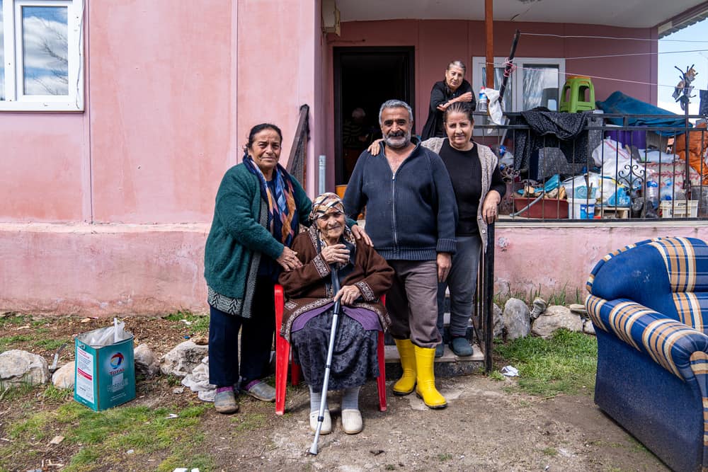 Semra Karaca, Sultan Kodaş, Hüseyin Kodaş and Şengül Kodaş (from left to right) live together as a family in Ören village, on the outskirsts of Malatya, Türkiye. They have been greatly affected by the recent earthquakes, as well as heavy flooding in the region.
"There are earthquakes on the one hand and rain on the other. We don’t know what will happen in the future. I’m here with my wife, my siblings, my children, and my mother.
Our belongings are drowned in water because of the flood, we can't find anything to wear, the neighbour brought us these clothes for now. We were staying in a tent, but the tent got flooded too.
We are now trying to dry what we took out of the house, including our family photos.
The children are scared. The situation is very dire”, says Hüseyin Kodaş