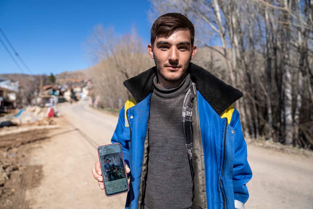 Yusuf Eren Ozkan, 22, is a student in Düzce Univeristy. He wants to be a chef. In this picture, he shows a photo of him cooking in a restaurant he works at part-time.
“I came to visit my parents when I had a break from school. The night of the first earthquakes, I was playing video games in my room. At first, I thought it was going to stop shaking after a few seconds, but then I realised this was going to be bigger.
After the first earthquake, me and my family still stayed in our house, and we turned on the TV and tried to find out what happened through the news. That’s when the second earthquake happened, and things got a bit tougher for us.
We went outside and it was very cold, there was a lot of snow on the ground and falling from the sky. Then a rock fell and hit me and my father, and we were injured. We eventually set up a tent by ourselves for protection.
Now, me and my family are working in a communal restaurant, making and serving food for about 4,000 people. I’m here to help, I Iove Polat, but I feel hopeless about this village now. I have many dreams and I just want to live somewhere else. I want to pursue my dream of becoming a chef.”