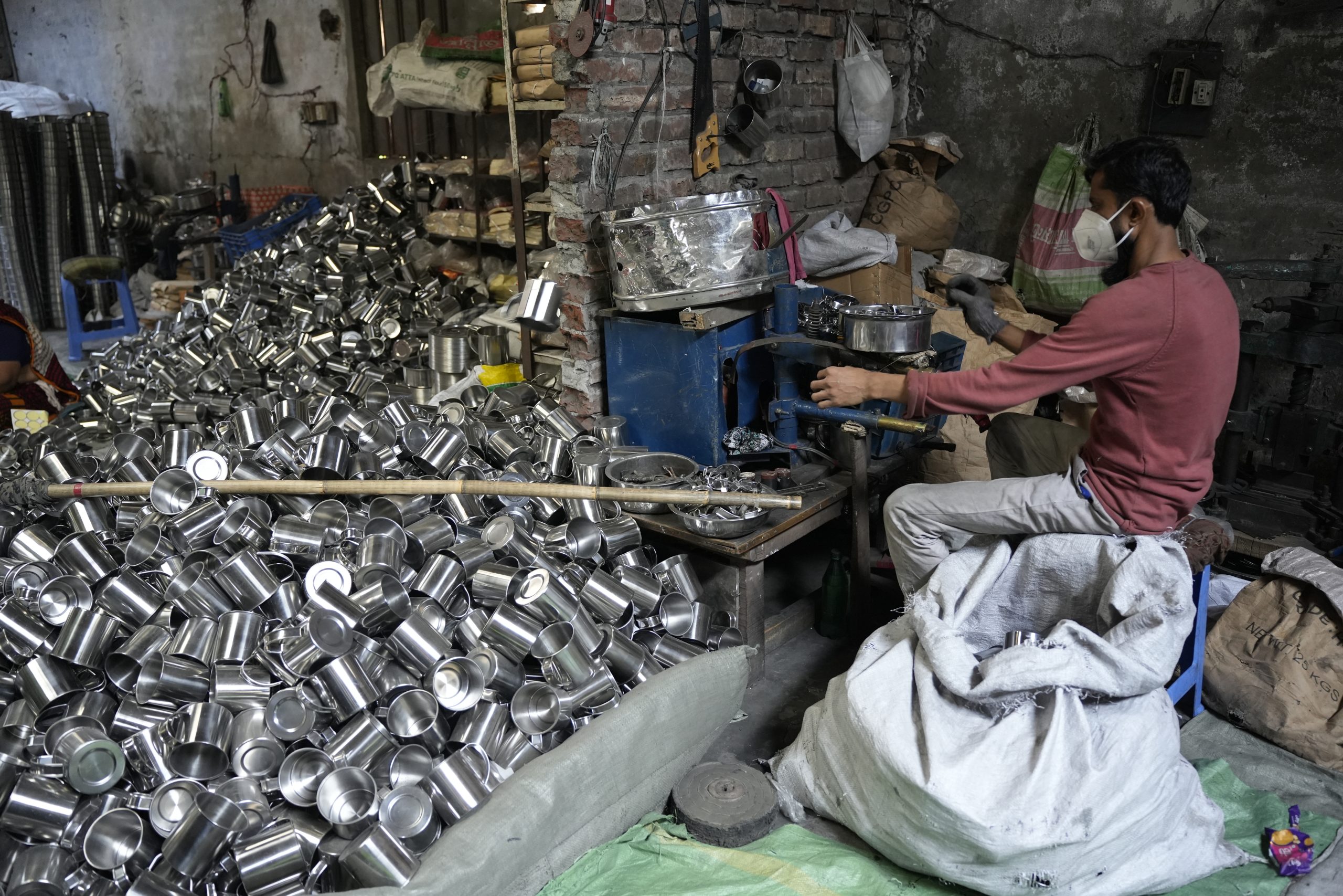A metal factory in Kamrangirchar where a worker is wearing a mask while dealing with metal items. MSF teams in Kamrangirchar worked closely with the factory workers during occupational health (OH) sessions for factory workers. ©️ MSF