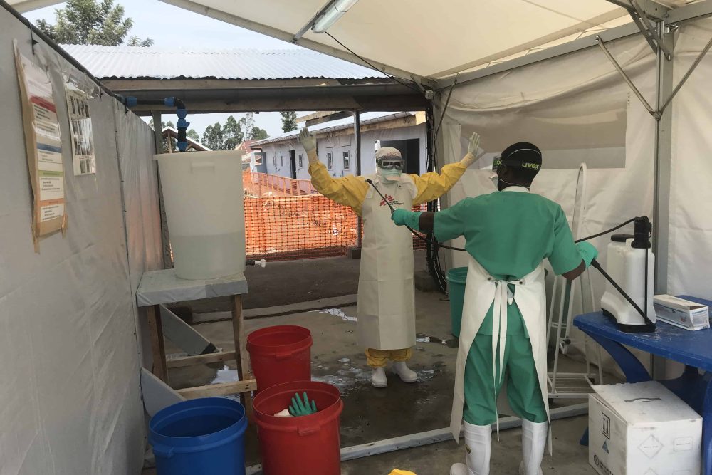 Ebola treatment center in Goma A staff undressing after providing care to patients.
